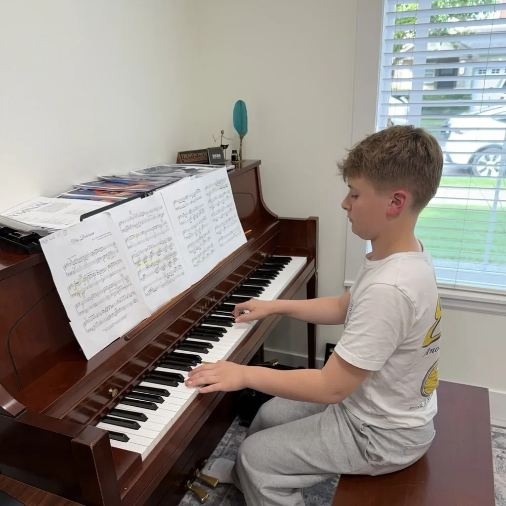 A student practising at the piano at home